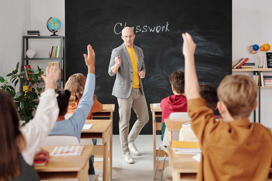 Man in Gray Suit Jacket Raising His Right Hand